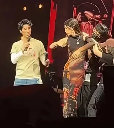 Ella请工作人员上台帮她剪掉袖子，好跟王力宏掰手腕。（互联网）