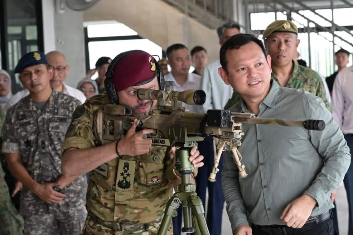 文莱王储兼首相署高级部长比拉赫（左）星期三（9月30日）上午在国防部高级政务部长扎吉哈的陪同下，参访新加坡武装部队军训城，并体验突击步枪和狙击步枪射击。（国防部提供）