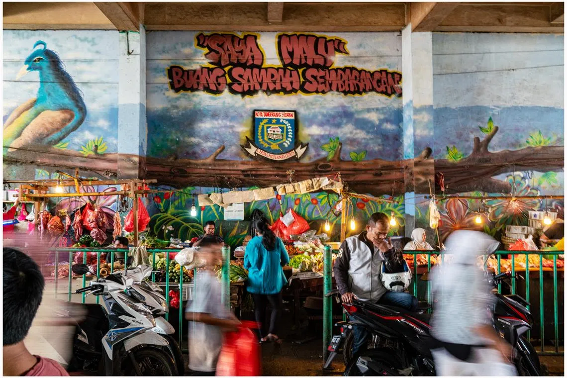 摩托、人流在菜市交织成一部生活交响曲。（姚耀光摄）