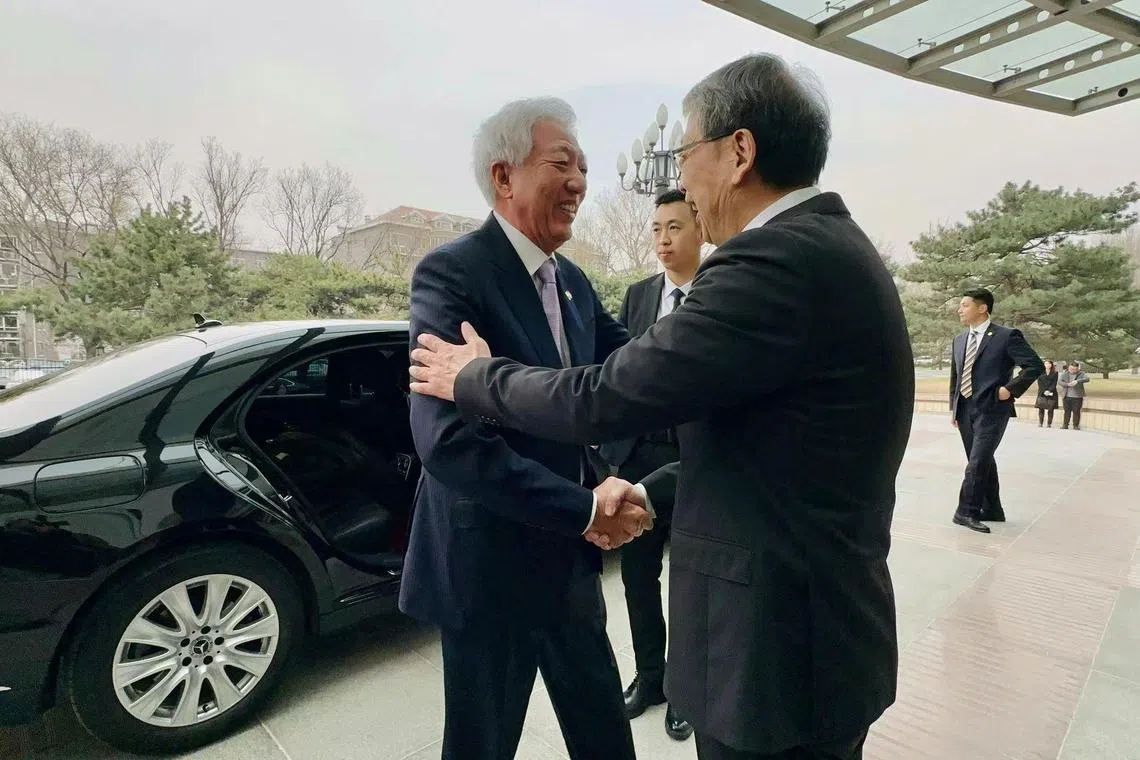 国务资政兼国家安全统筹部长张志贤（左）抵达时，中共中央党校校长陈希（右）在大楼外迎接。（杨丹旭摄）