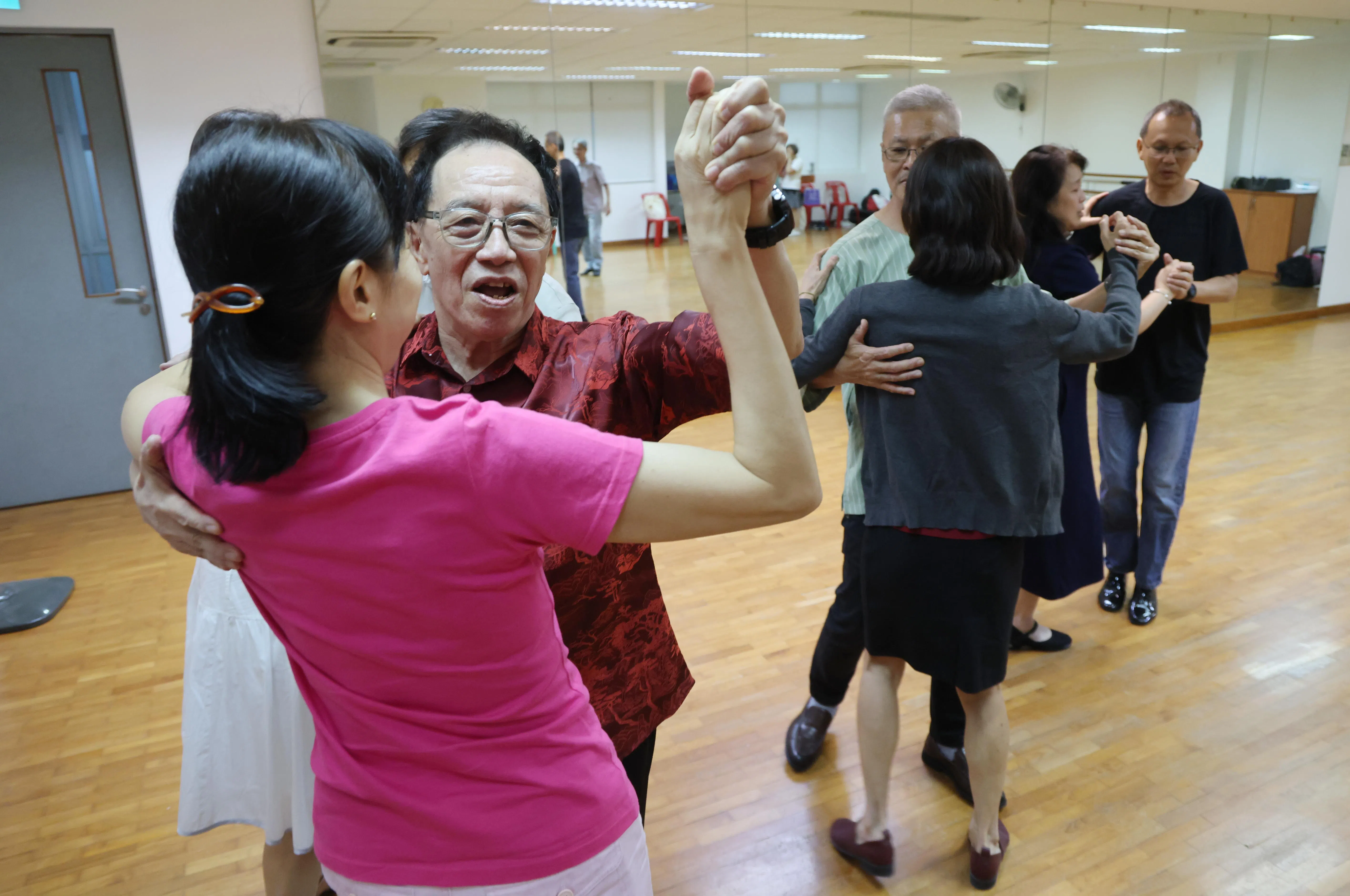 冼福荣（左，面向镜头）原为工厂主管，被裁员后转行成为舞蹈老师，至今已执教30多年。（唐家鸿摄）