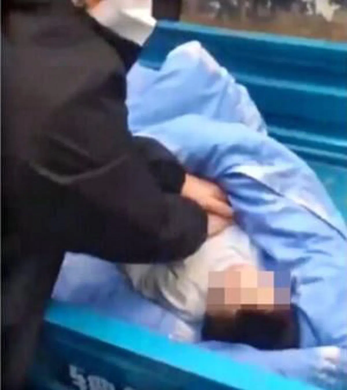 小区居民正在给躺在三轮车的车斗中的孩子作心肺复苏。（视频截图）