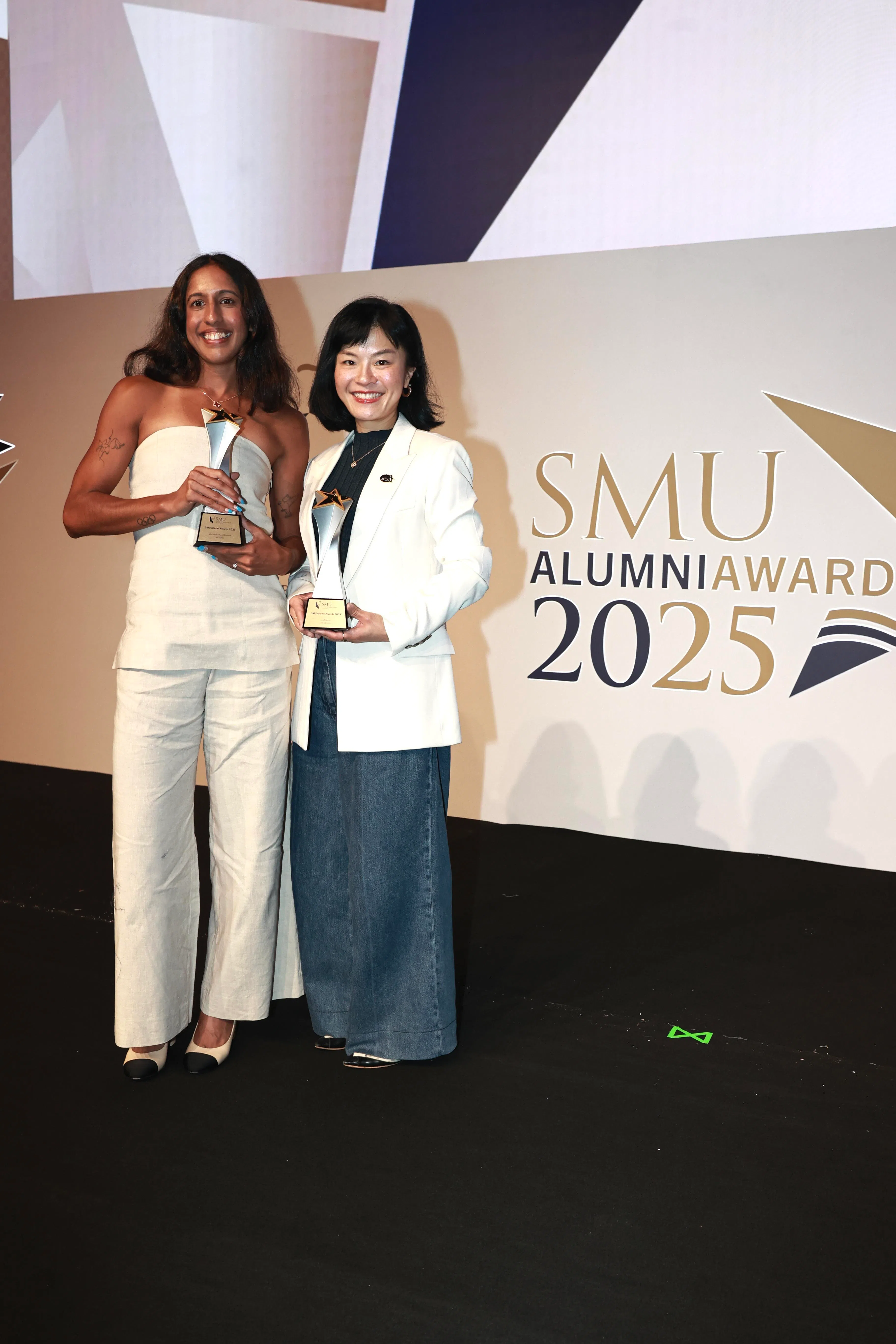 新加坡“女飞人”珊蒂（左）田径赛场外罕见的一身正式装扮，与同获新大首届杰出校友奖的生物技术公司TurtleTree创办人兼首席执行官林凤如合影。（周国威摄）