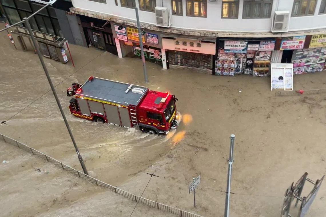 强降雨造成的洪水持续至星期五早上，一辆消防车在受洪水淹没的马路上行走。（路透社）