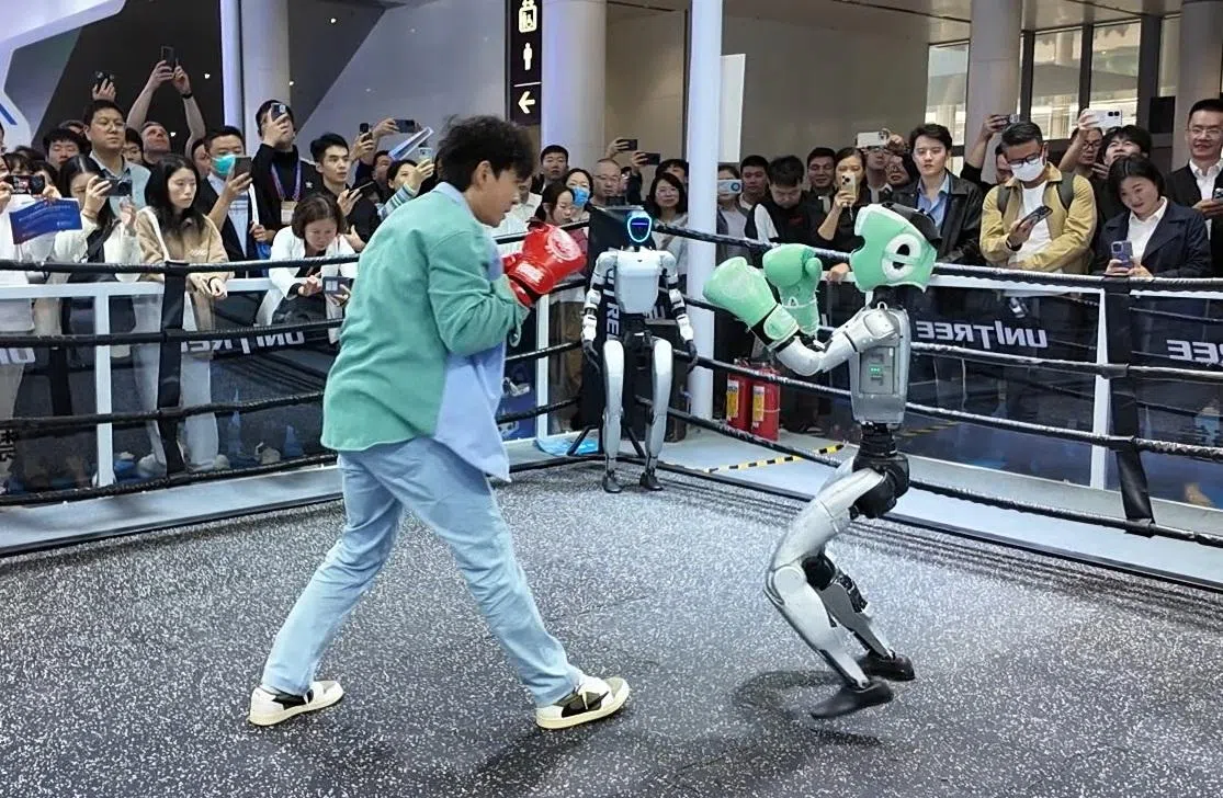 主持人田铭耀在深圳AI会展上与AI机器人打一场。（新传媒提供）