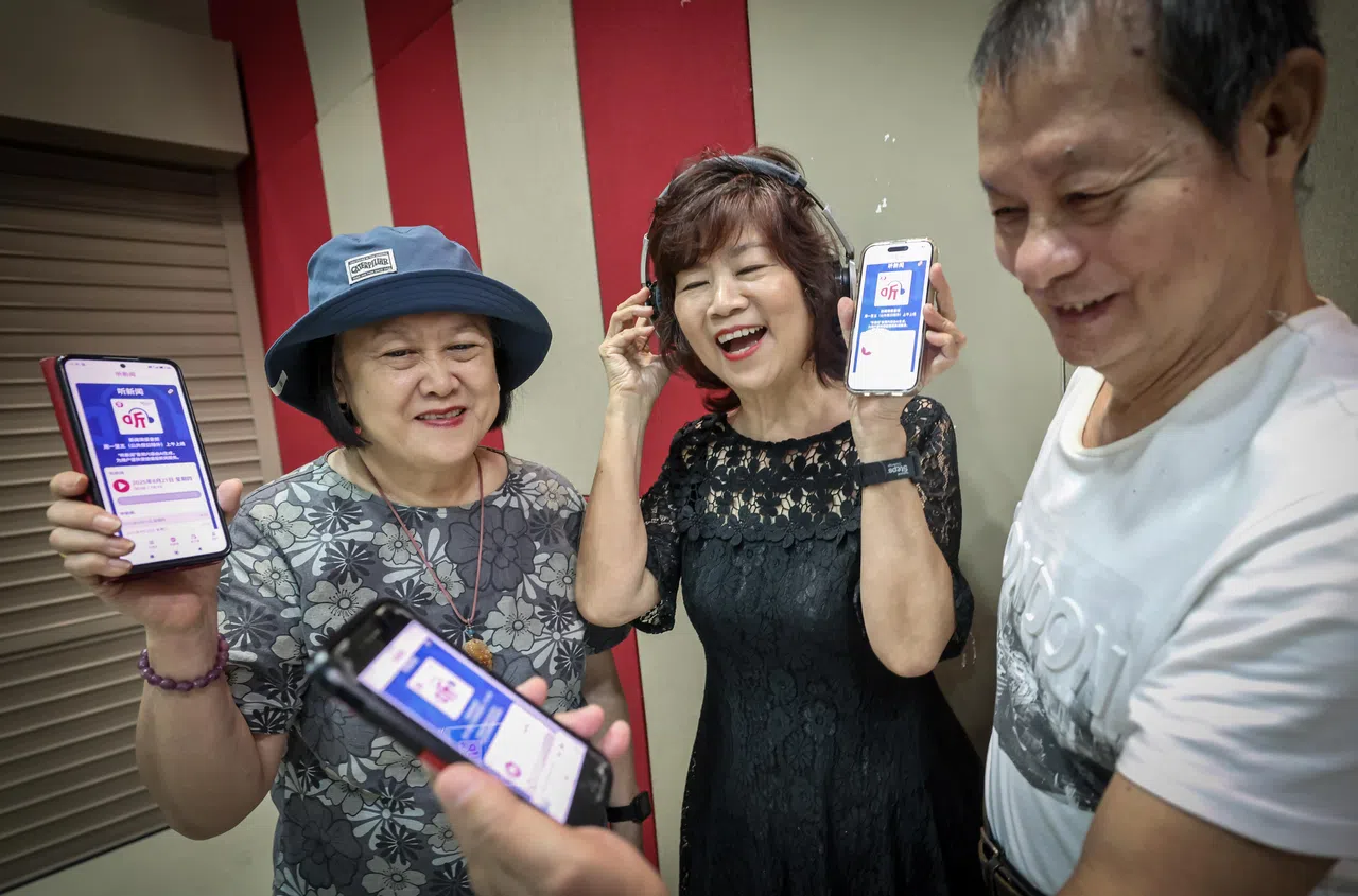 三名已退休的读者（左起）郭银娟（70岁） 、罗慧玲（66岁）和陈楷锋（73岁），是《联合早报》“陪你看报纸”活动的义工，星期四在早报应用正式推出“听新闻”功能活动上，拿起手机试用这个新功能，好把好康也介绍给亲朋好友。（唐家鸿摄）