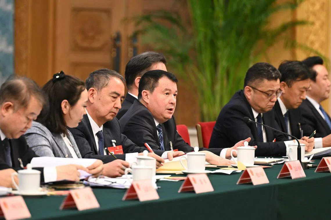 新疆人大代表团星期四（3月7日）举行开放团组会议，审议政府工作报告并回答记者提问。 图为全国人大代表地力下提·帕尔哈提（左四）答记者问。