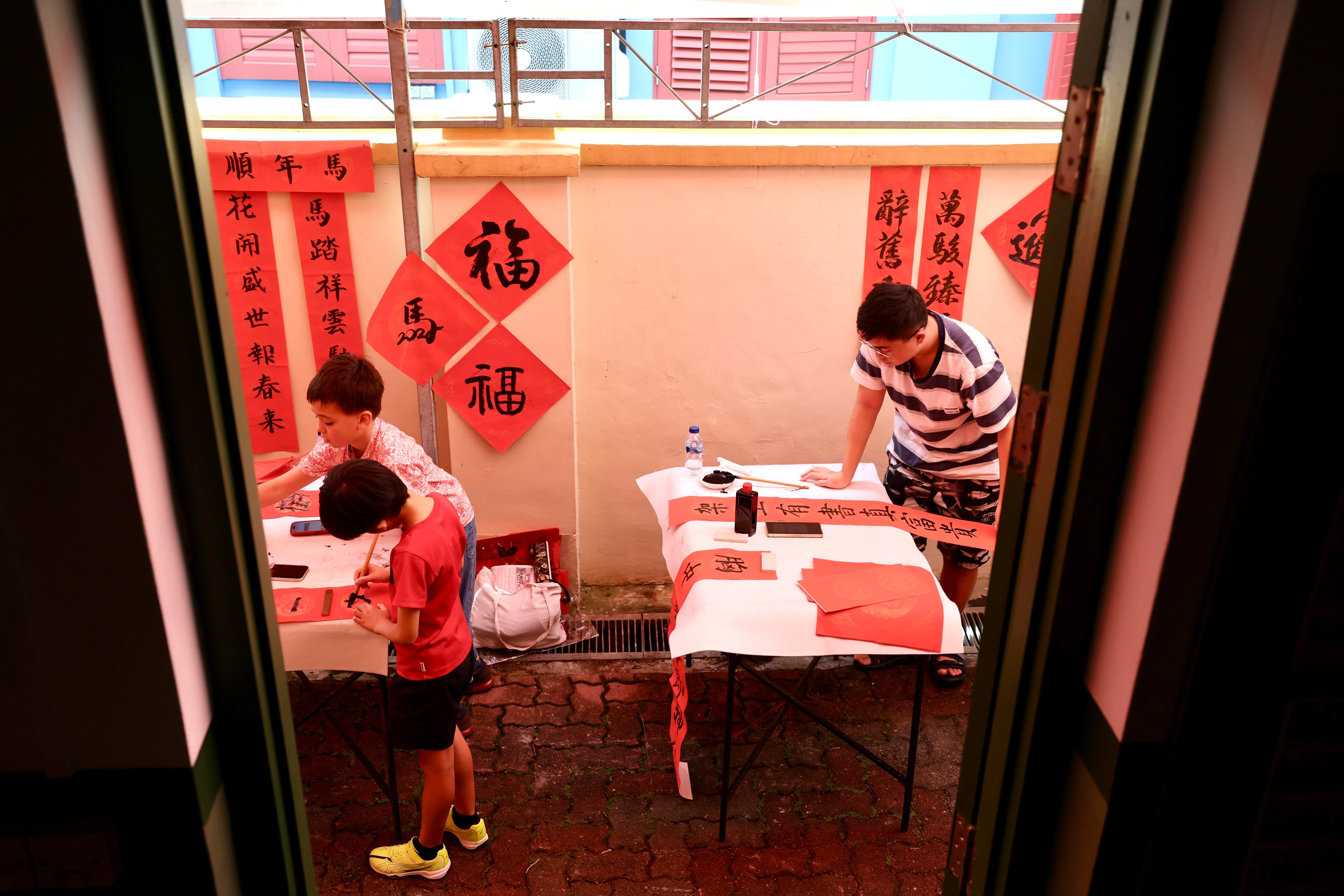 活动吸引了约1000名公众参与，上至95岁高龄，下至3岁半的幼童，在红纸上写下“福”“春”“吉”等新年的寄望。（陈斌勤摄）