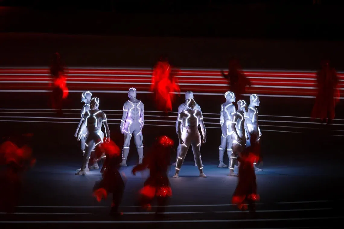 LED表演者在场地上疾驰，划出炫目的光轨。（海峡时报）