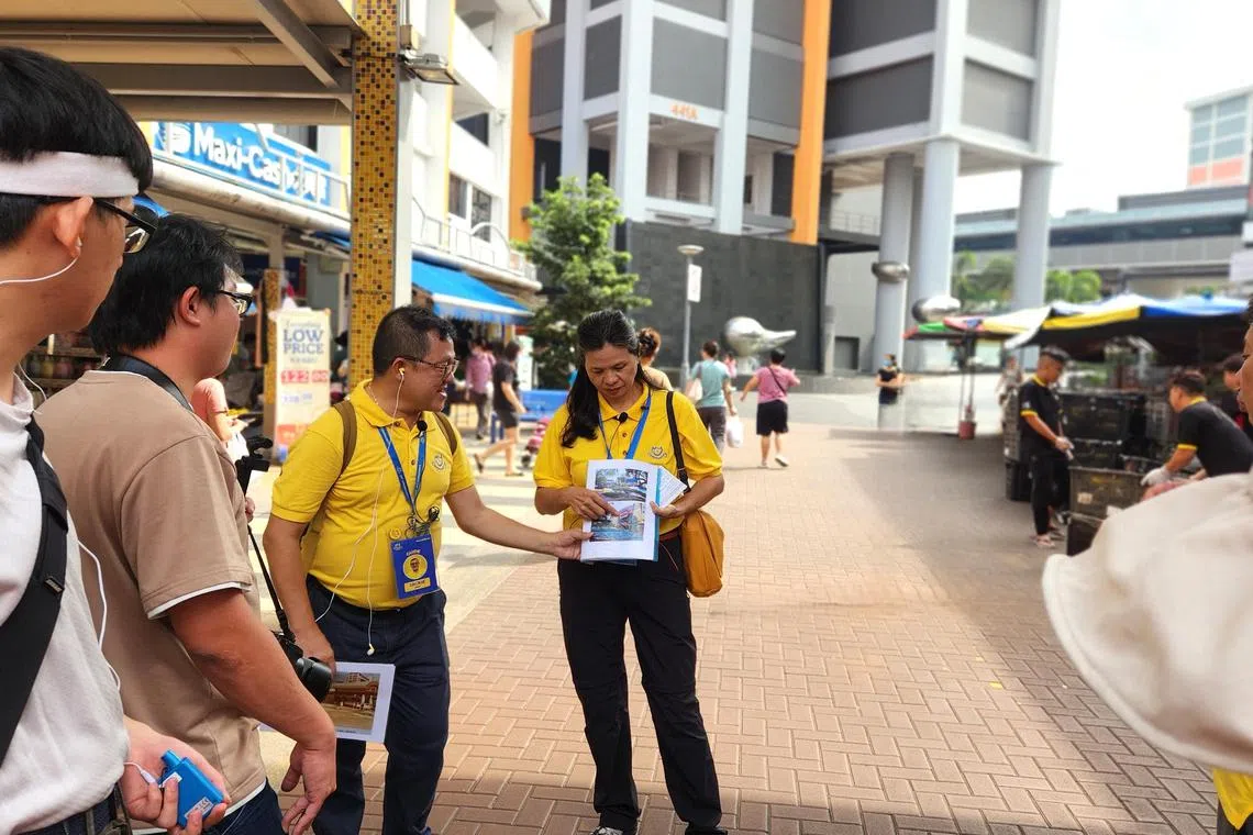 “我的社区”义务导览员梁誓杰（左三）和孙锦凤（左四），讲解金文泰中心数十年来的变与不变。（陈爱薇摄）
