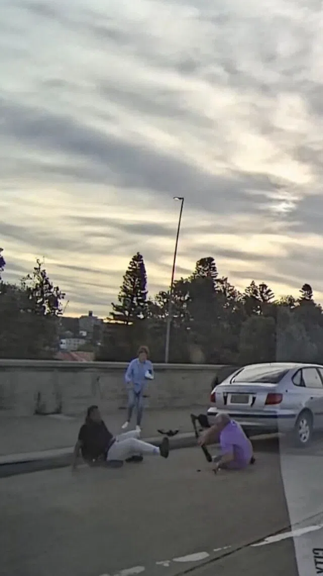 画面显示，一名身穿淡紫色衬衫的年长男子，与一名女子一同扑向枪手，试图夺下他手里的长枪。男子随后与枪手在银色车后方激烈扭打。（路透社）