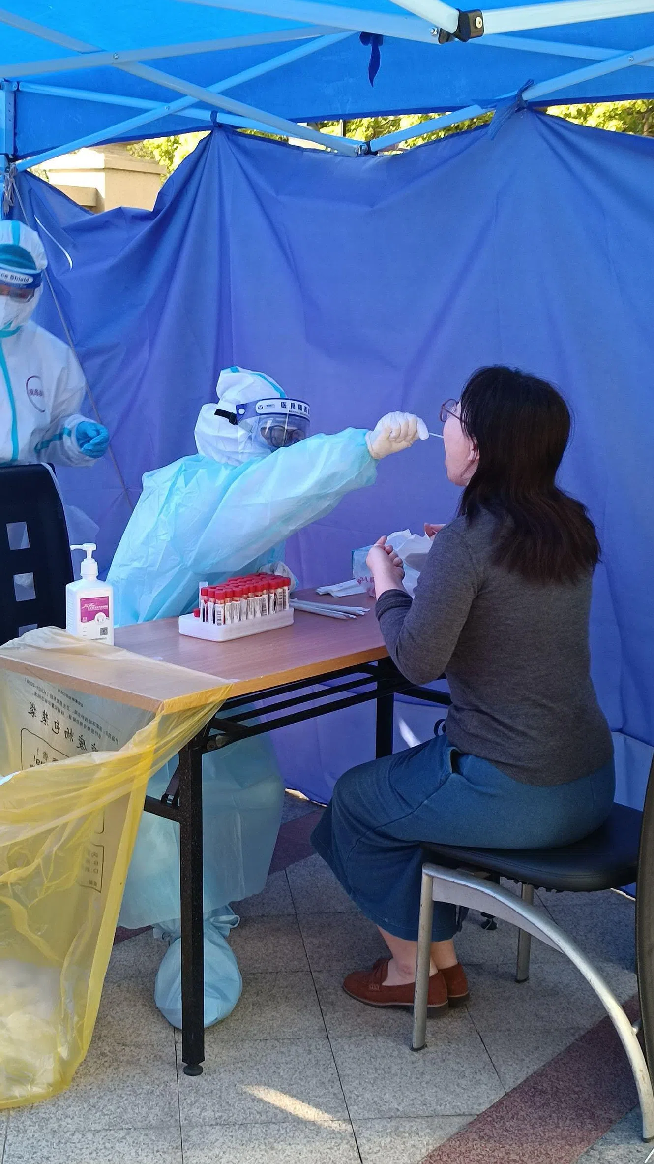 上海封城期间，核酸检测如同家常便饭。图为邻居为记者拍摄的接受检测过程。（档案照片）