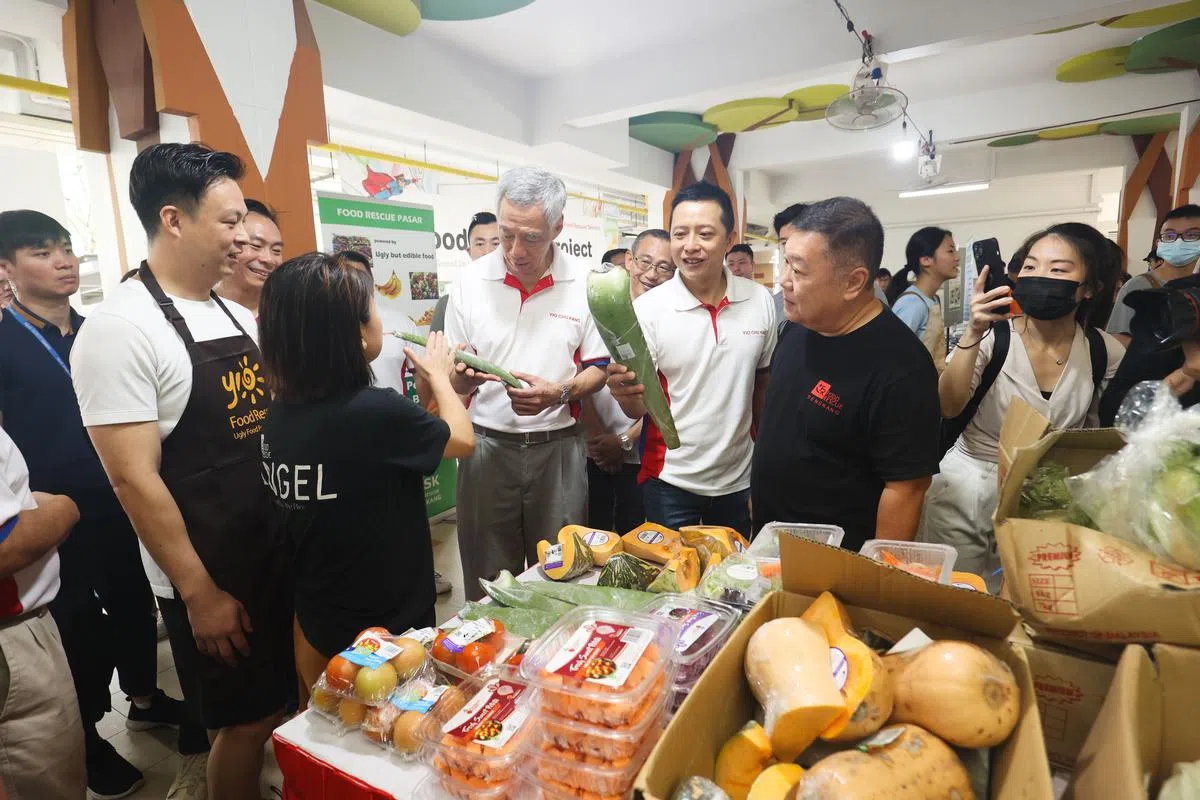 李总理（中）也了解了区内其他环保计划，如杨厝港Food Rescue计划。Food Rescue计划将卖相不好但仍可食用的食材，免费派发给居民。（蔡家增摄）