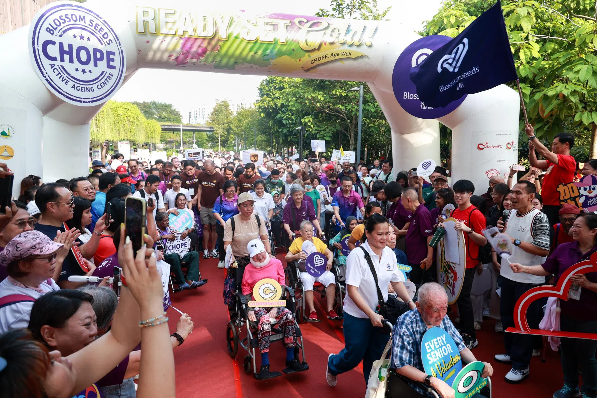 三巴旺集选区议员、卫生部长王乙康（红衣挥旗者）挥旗启动福善第四届步行活动，并陪同参与者完成1.5公里的步行路程。（张俊杰摄）