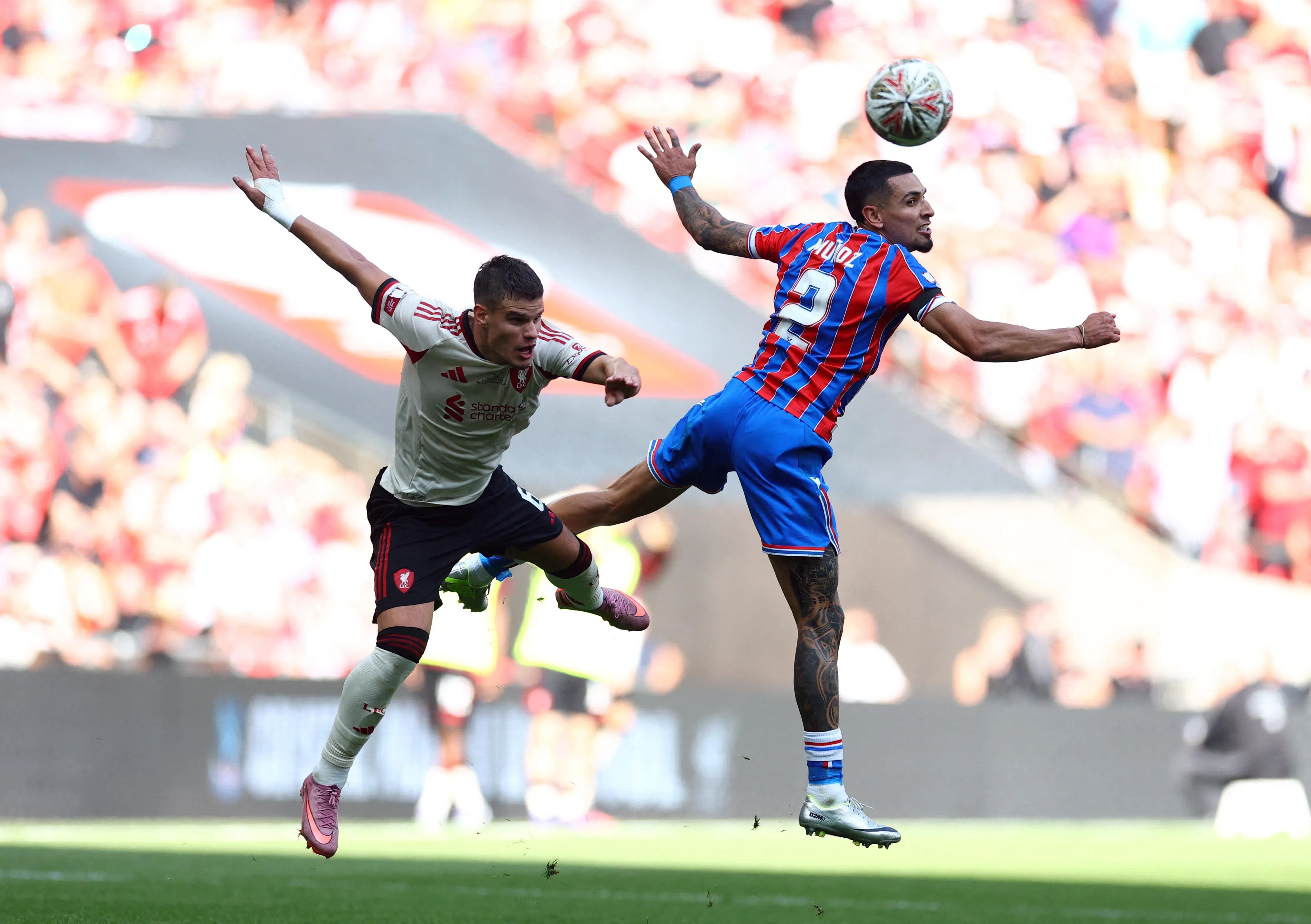 红军左后卫科尔克兹（左）上场比赛被对手的右中场穆尼奥斯（右）压制，但也做出关键拦截，表现总体合格。此役他将面对旧主，期待有好的发挥。（路透社）