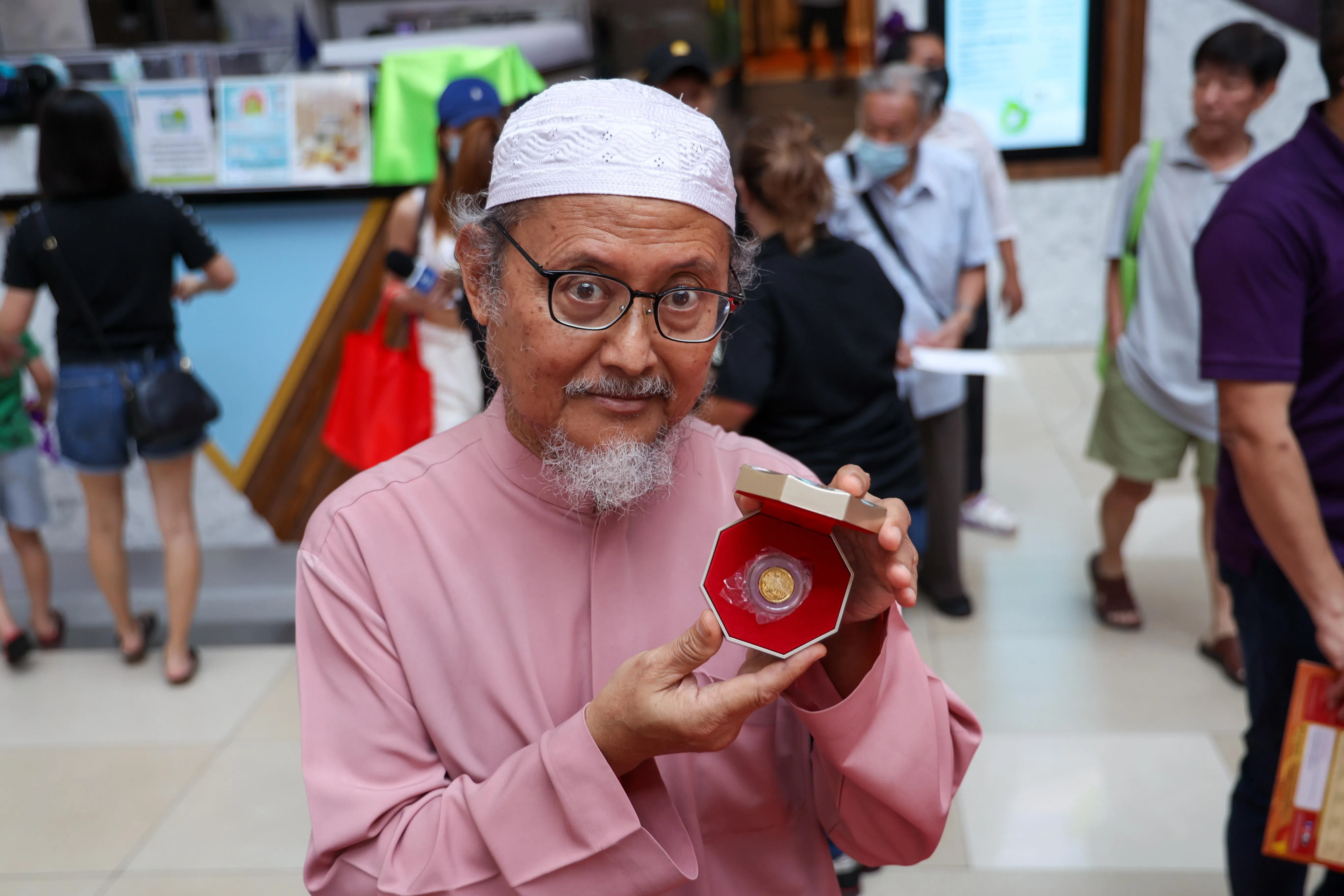 70岁的回教徒同胞阿都达卡有四分之一华族血统，他经过唐城坊纪念币售卖会时看上了2024年龙年纪念币的设计，决定花1172元购买一枚四分之一安士的金币送给妻子。（白艳琳摄）