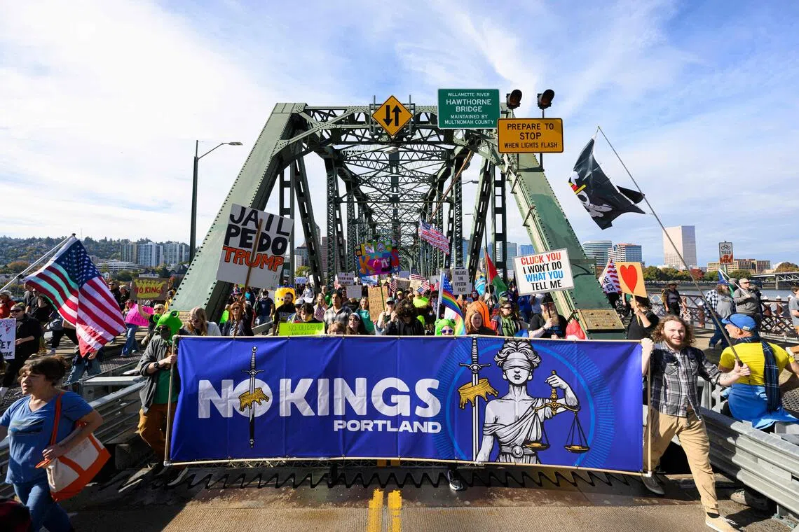 10月18日，俄勒冈州波特兰市的示威者在“不要国王”抗议活动中游行穿过霍桑大桥。（法新社）
