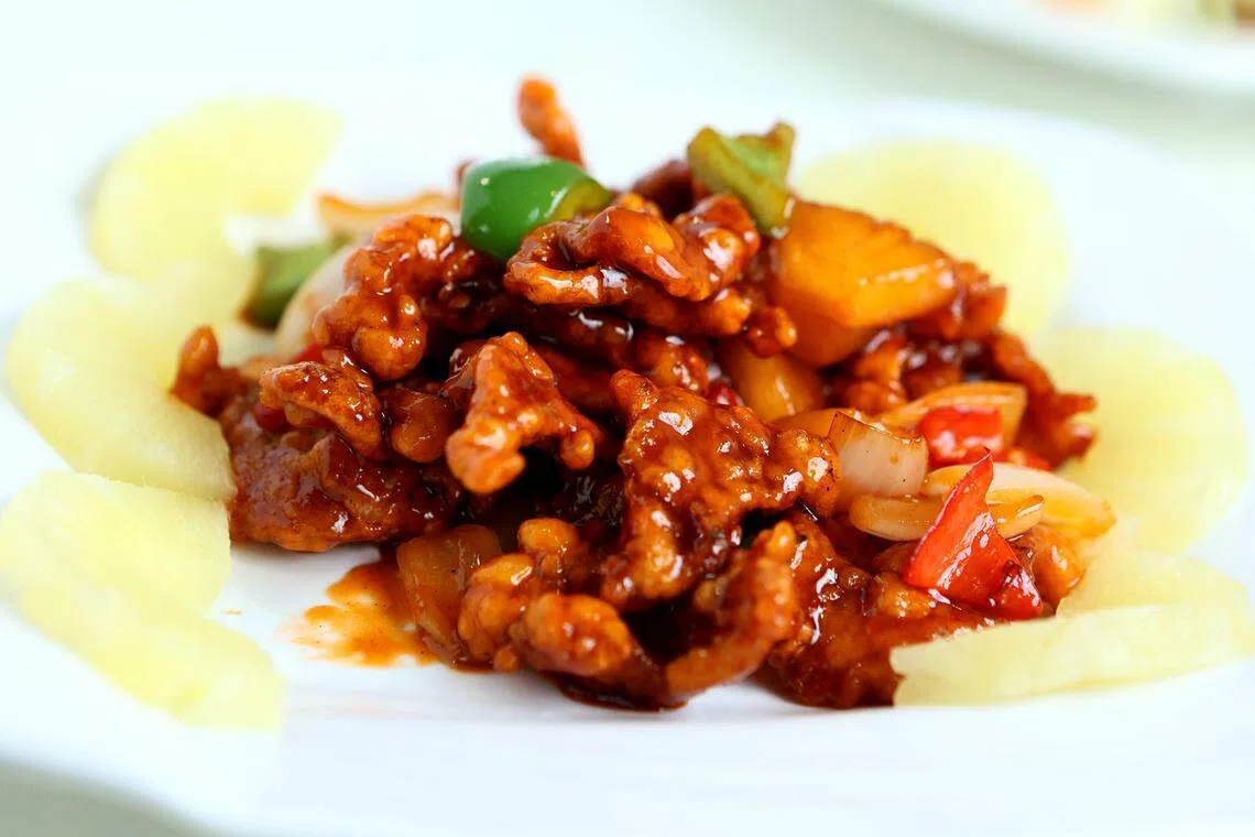 外酥里嫩的菠萝咕噜肉，酸甜适宜。（龙国雄摄）