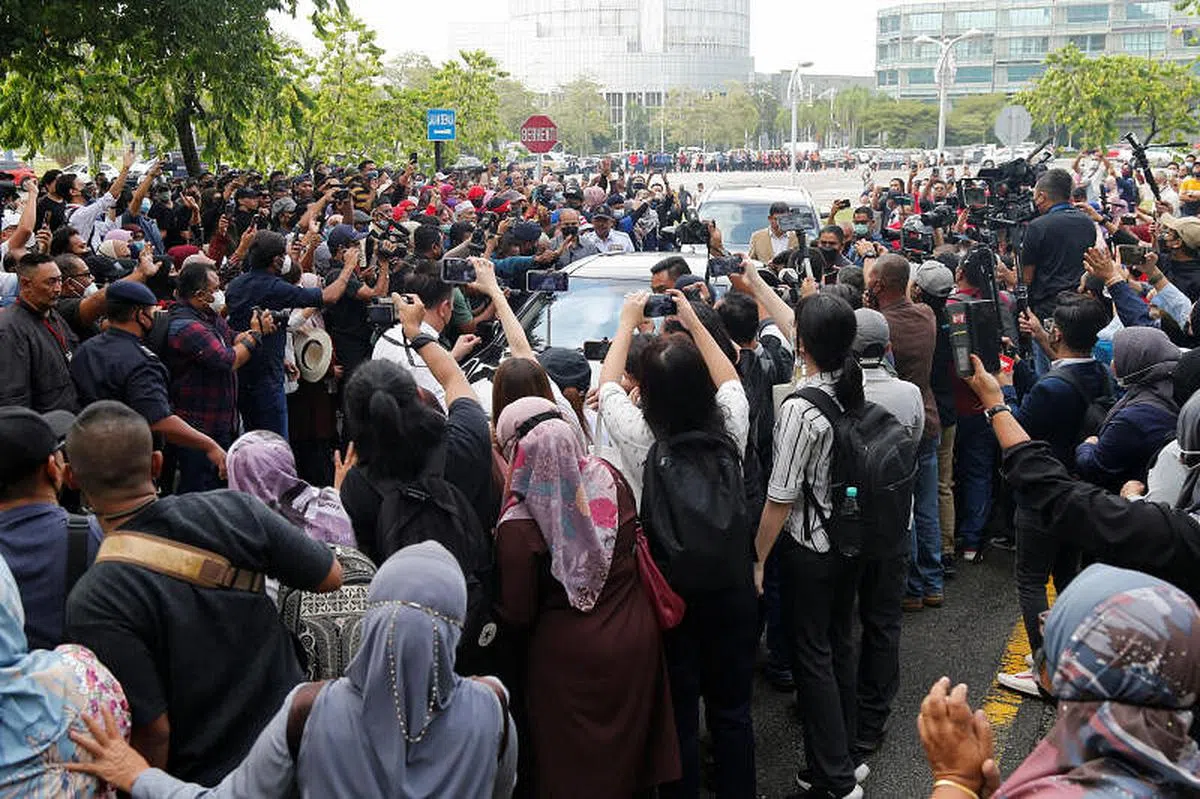 23日上午，纳吉乘轿车抵达联邦法院时，数百名支持者聚集在法院外为他加油打气。（路透社）