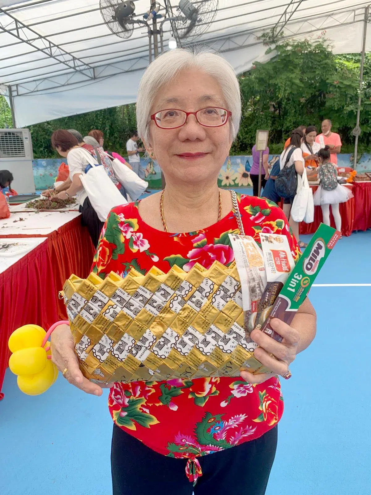 庄美蕾对可持续发展的摊位感兴趣，看到人们把饮料和饼干包装再循环利用，制作出精美包包，让她赞叹。（黄银川摄）