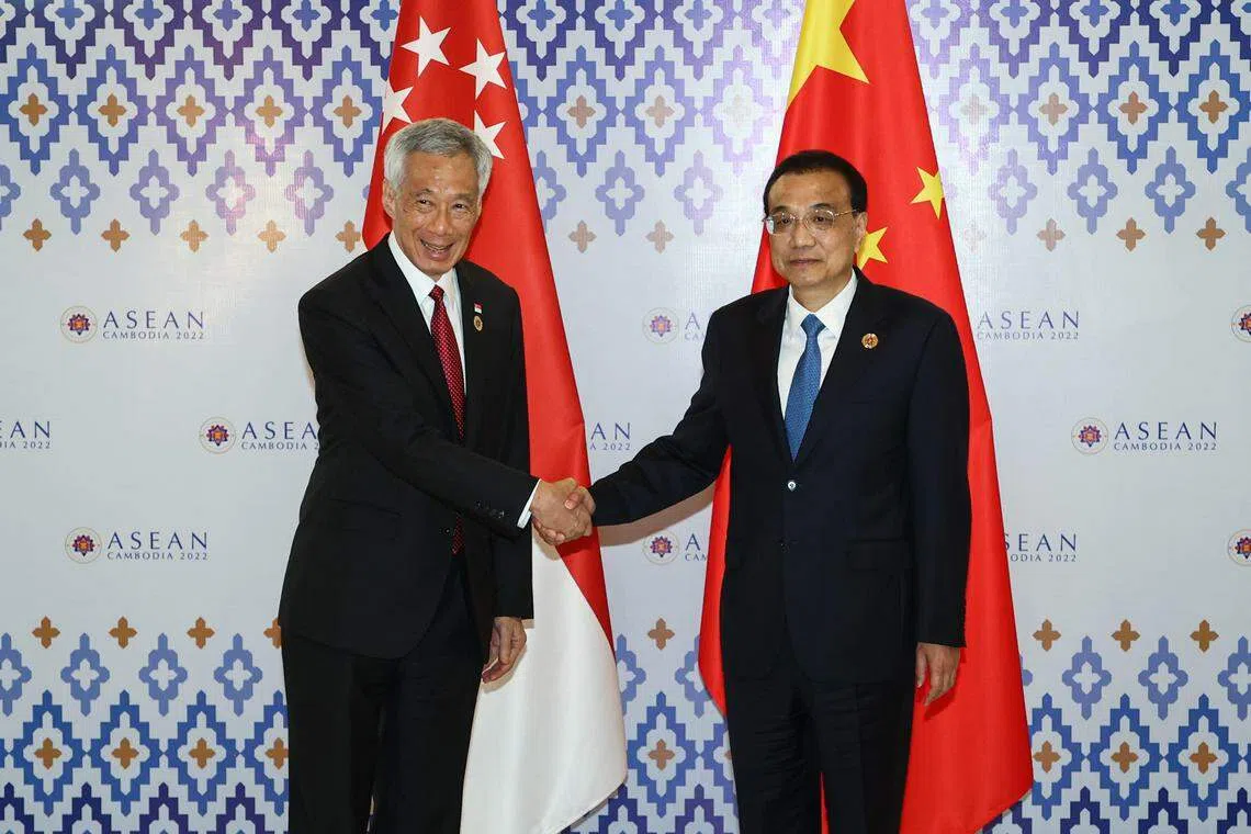 2022年11月11日，新加坡总理李显龙（左）和中国总理李克强在柬埔寨金边举行的亚细安—中国峰会上聚首。（档案照片）