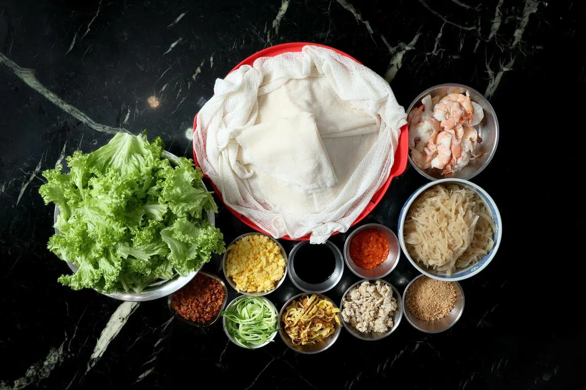 薛丽莉准备的薄饼食材特别多，有沙葛、虾仁、鸡蛋、黄瓜、豆干、生菜和花生碎等。（龙国雄摄）
