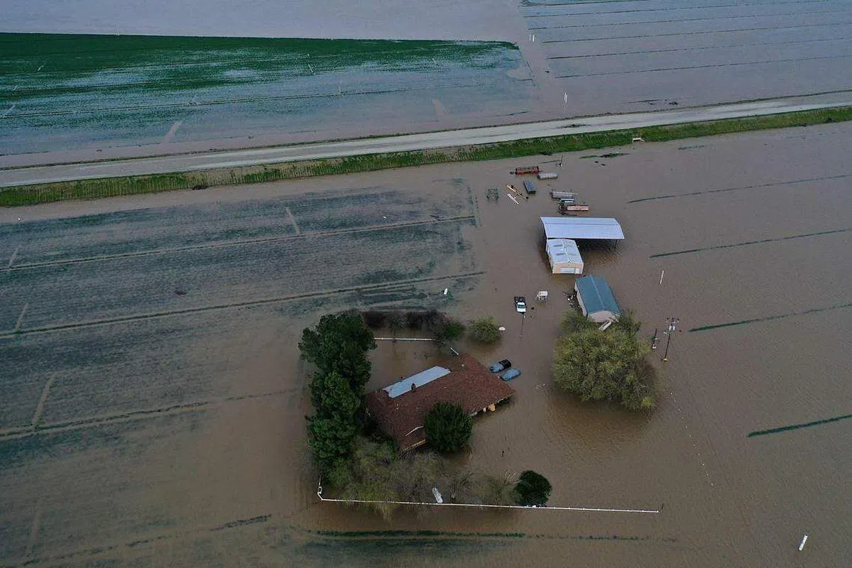 加州连日暴雨，河水泛滥成灾，图莱里县（Tulare County）大片农田、住家、道路被淹没。（法新社）
