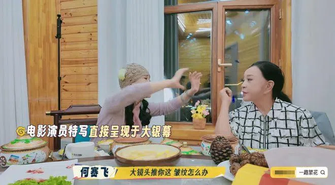 何赛飞（左）在刘晓庆面前做出放大镜头动作，怼她说镜头会照出皱纹。（视频截图）