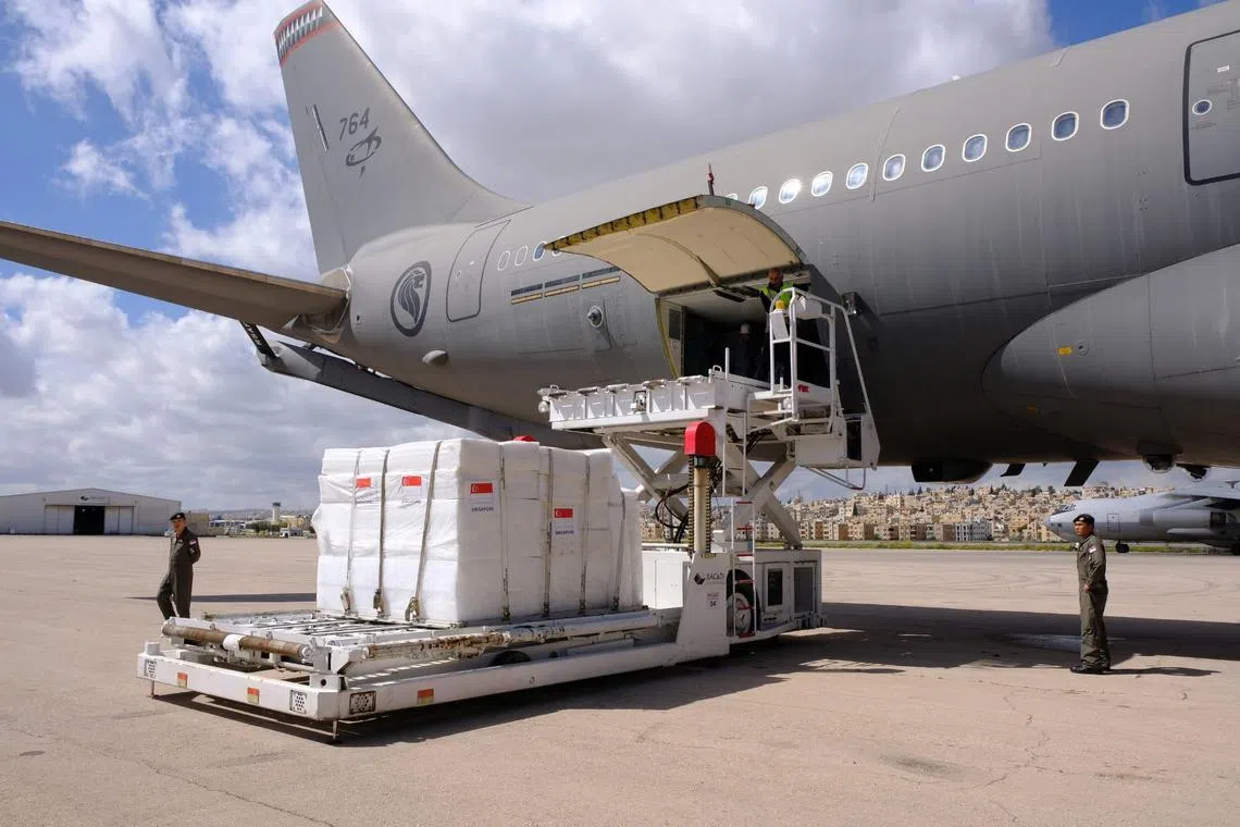 新加坡武装部队人员从我国空军A330多用途添油运输机，卸下援助加沙的第三批物资，以集中放入C-130机舱内，以便执行空投任务。（国防部提供）