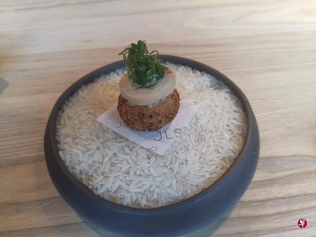林恬耀的海南鸡饭最新创作版本，上面是葱丝、姜蓉和鸡腿肉，馅皮加上参峇辣椒酱，馅料包括茉莉香米鸡饭、鸡冠、鸡心和鸡肝，口感丰富多层次。（温伟中摄） 