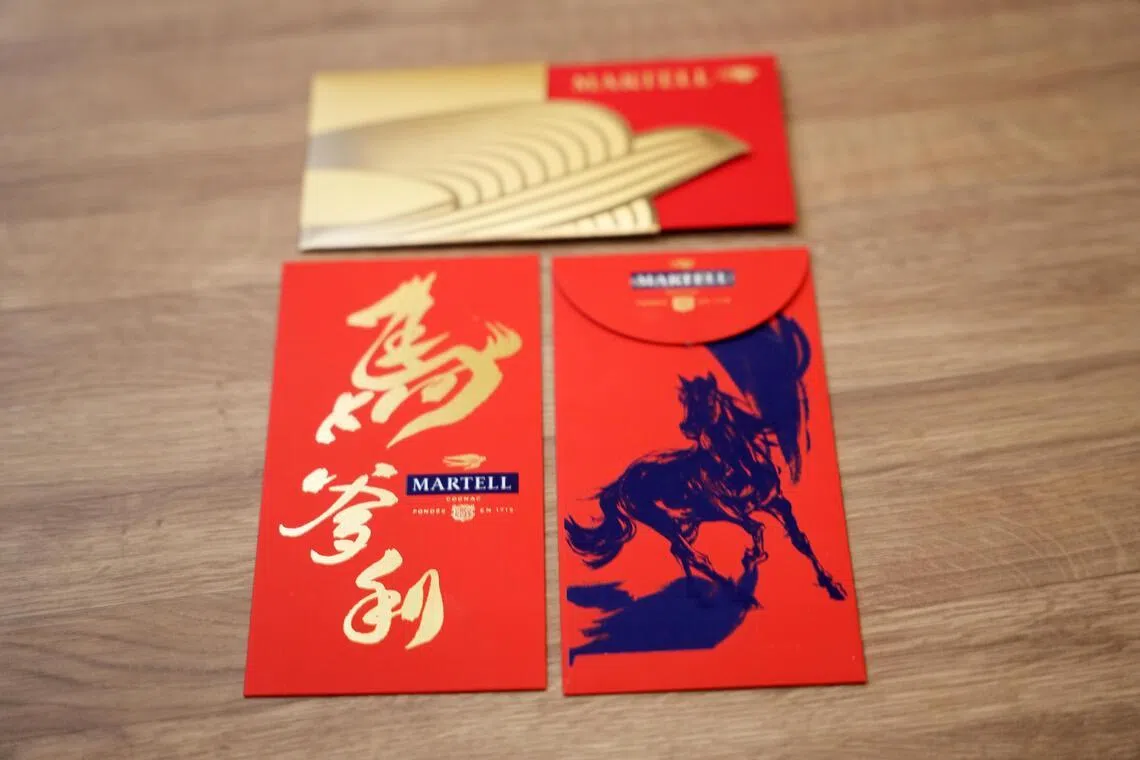 马爹利推出两款红包，一款是精致版金燕图（上），一款是蓝马书法。（谢智扬摄）