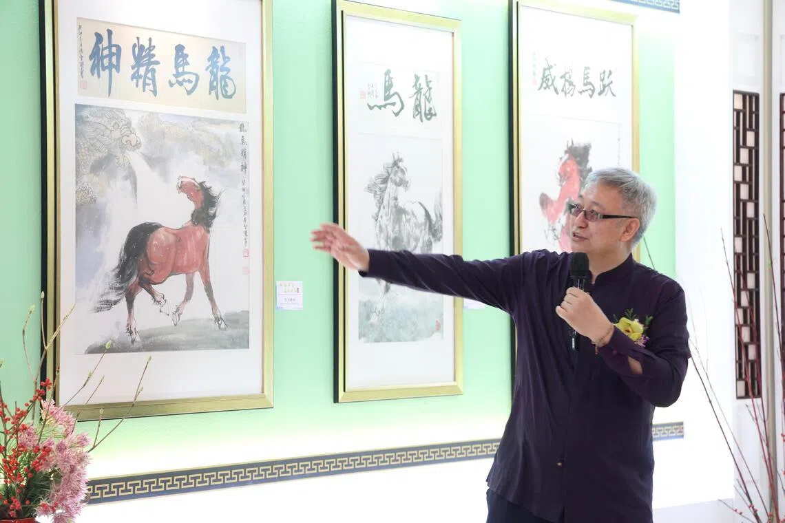 中国画家张智栋在新加坡佛光山，向参加画展开幕礼的宾客，一一介绍他的骏马画作。（郑一鸣摄）