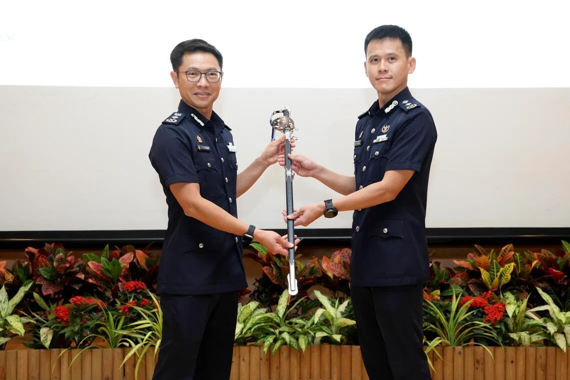 出任网络指挥处司令的王兴顺高级助理警察总监（右），从警察总监侯光辉手中接过指挥剑。（郑一鸣摄）