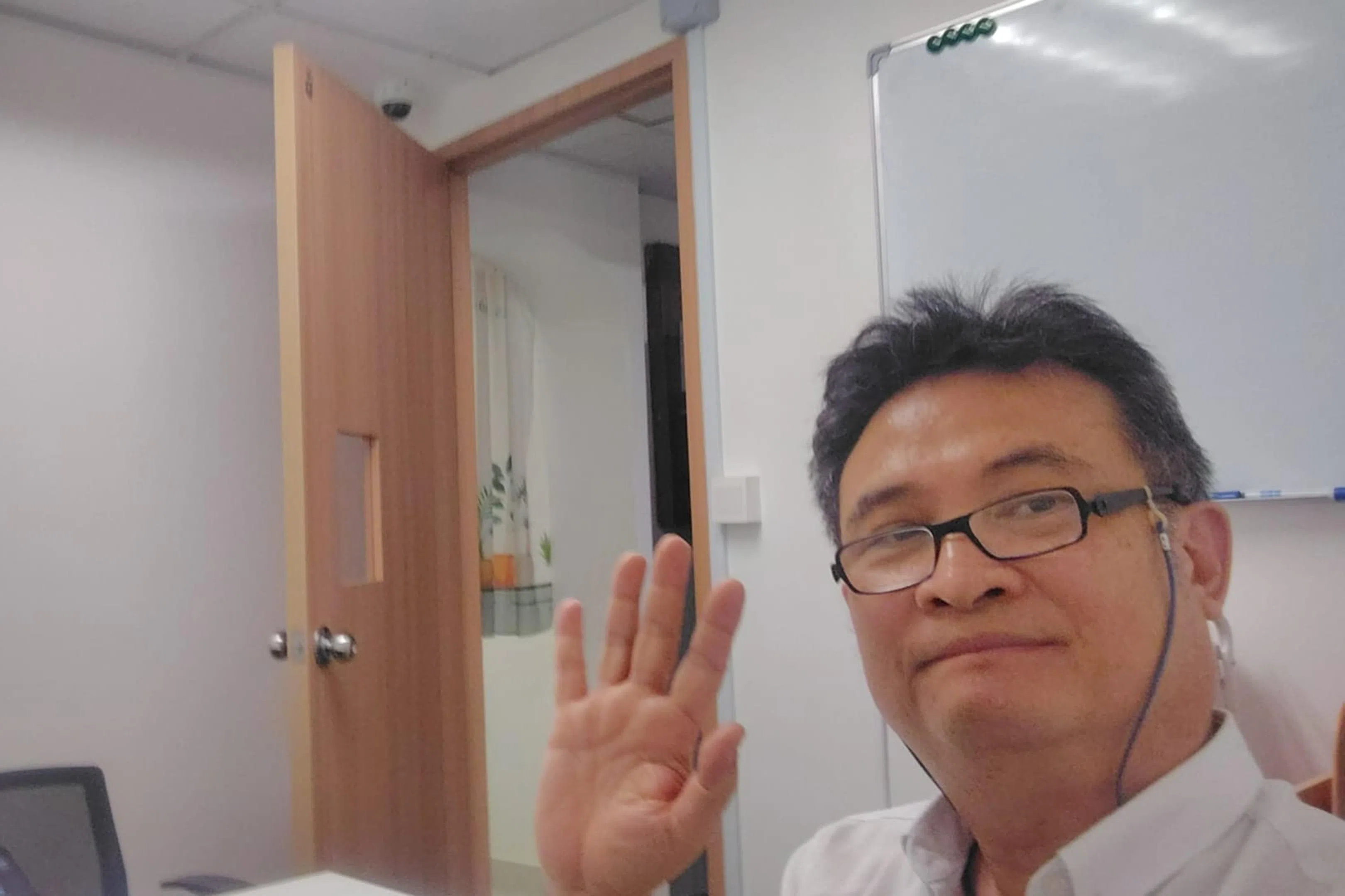 曾任职于科技公司的吴明辉，将家中闲置的十多副全新耳机随身携带送出。（受访者提供）