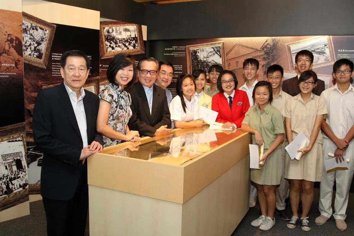 怡和轩俱乐部在2009年设立华文书籍奖，颁给修读高级华文的特选中学优秀生。图为怡和轩于2013年5月5日举行第五届华文书籍奖颁奖礼。时任教育部兼通讯及新闻部高级政务次长沈颖（左二）连同时任怡和轩主席林清如（左三），与另两名当时董事会成员谢万森（左一）和许福吉教授（左四），以及11名华文书籍奖得主在俱乐部内的先贤馆合照。（档案照片）