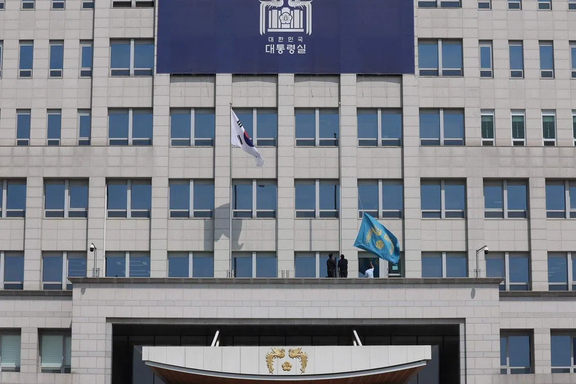 弹劾案判决公布后，总统办公室立即降下办公楼外的“凤凰旗”，象征总统权力的终结。（法新社）