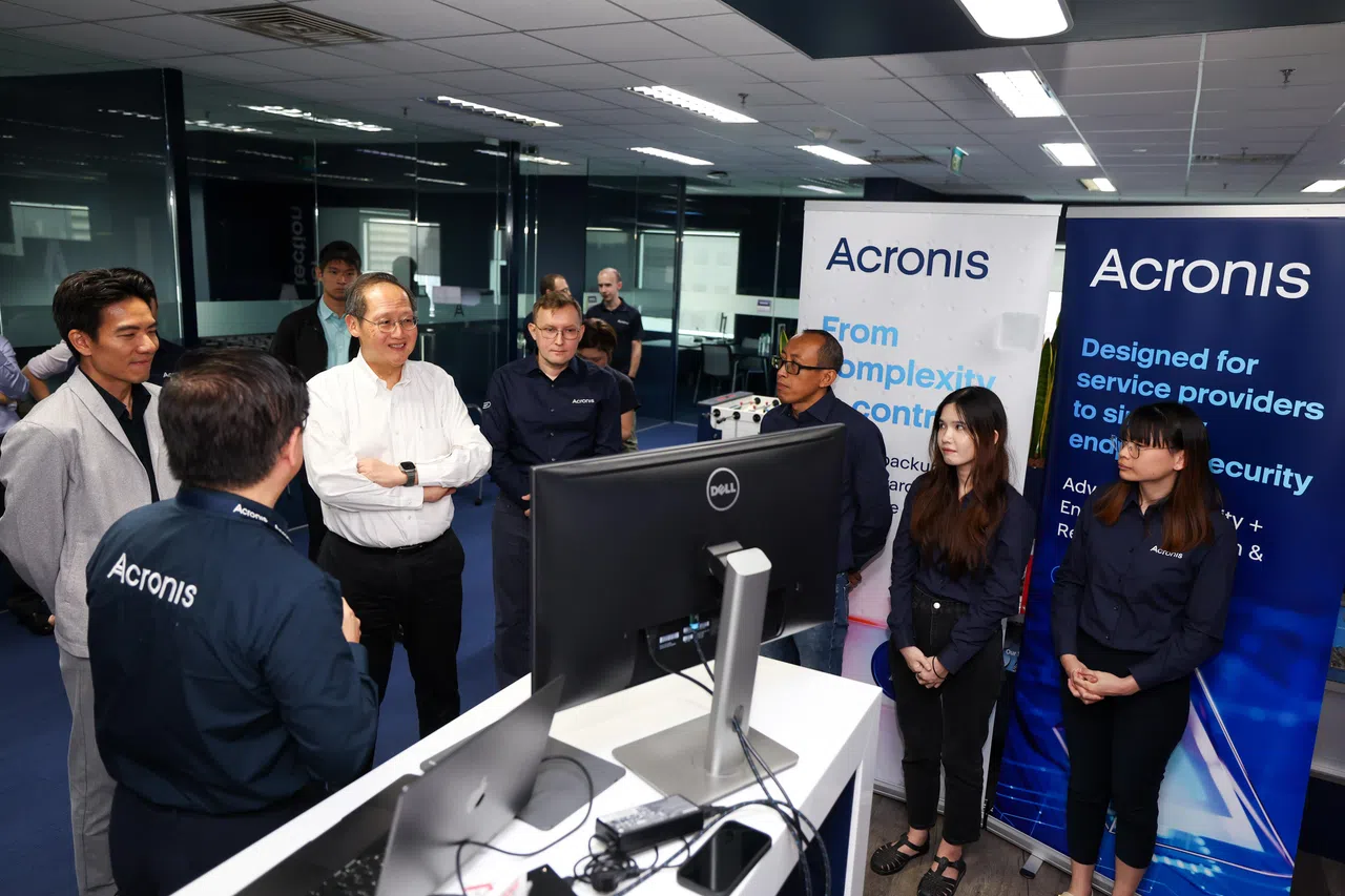 人力部长兼贸工部第二部长陈诗龙医生（右五），星期一（16日）下午走访数据保护及网络安全公司Acronis，与参与劳动力发展局科技专才转业计划的员工交流。右一起为参与计划的Acronis员工丁子慧、郑佩琪及哈利勒（Khalilur Rahman）。（林明顺摄）