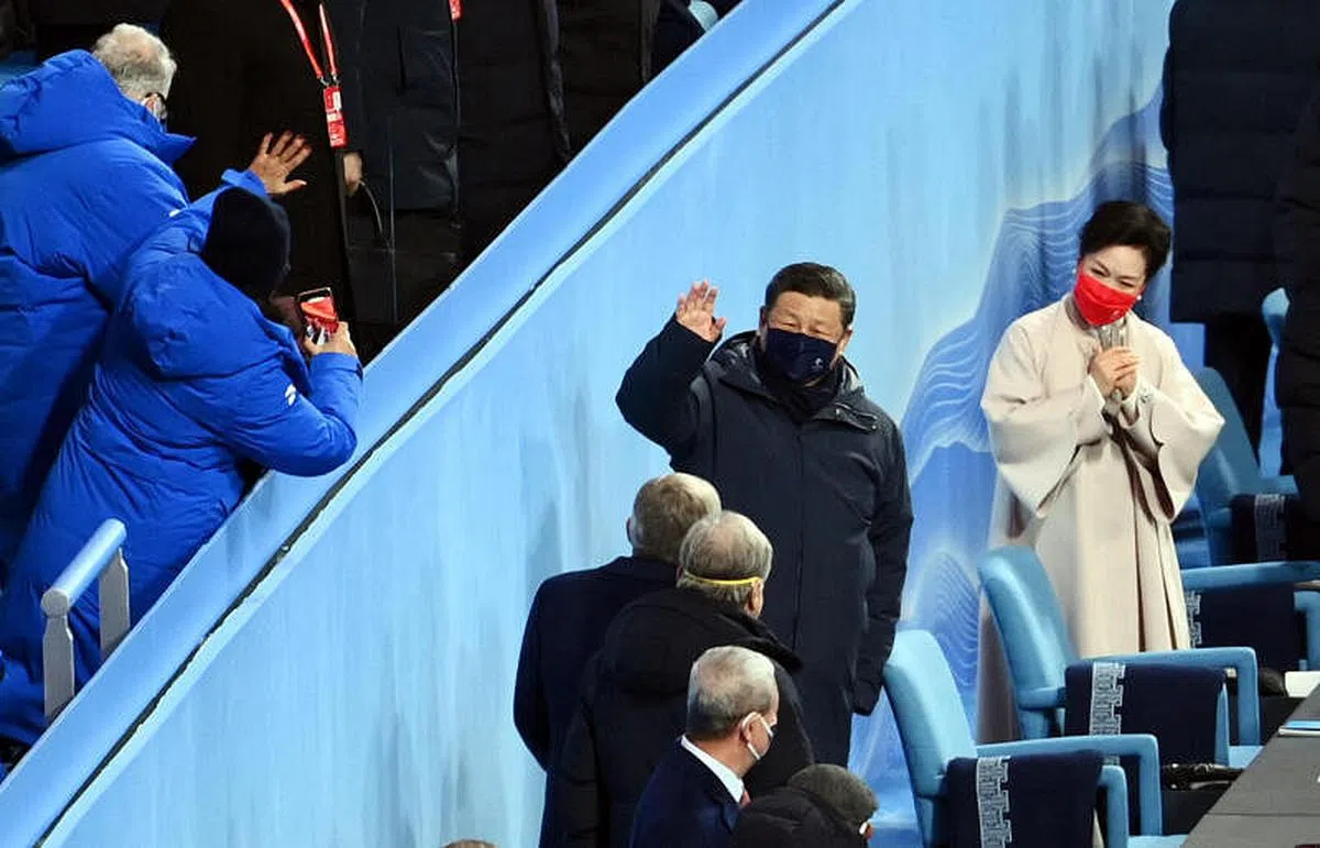 中国国家主席习近平向参加冬奥开幕式的来宾挥手致意，他身边穿白衣的是夫人彭丽媛。（路透社）