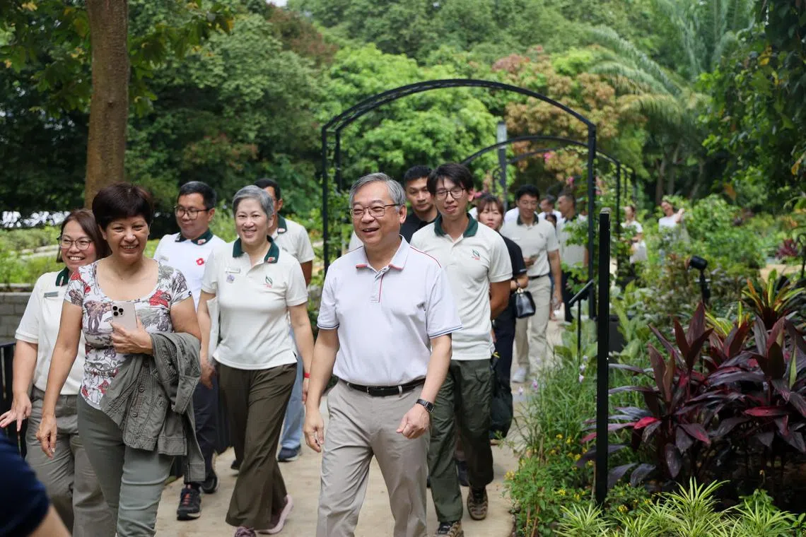 副总理兼贸工部长颜金勇（前右）与总理公署部长兼财政部及国家发展部第二部长英兰妮（前左）参观园艺园林，了解“锦簇社区”20周年展示区的园艺成果。（张俊杰摄）