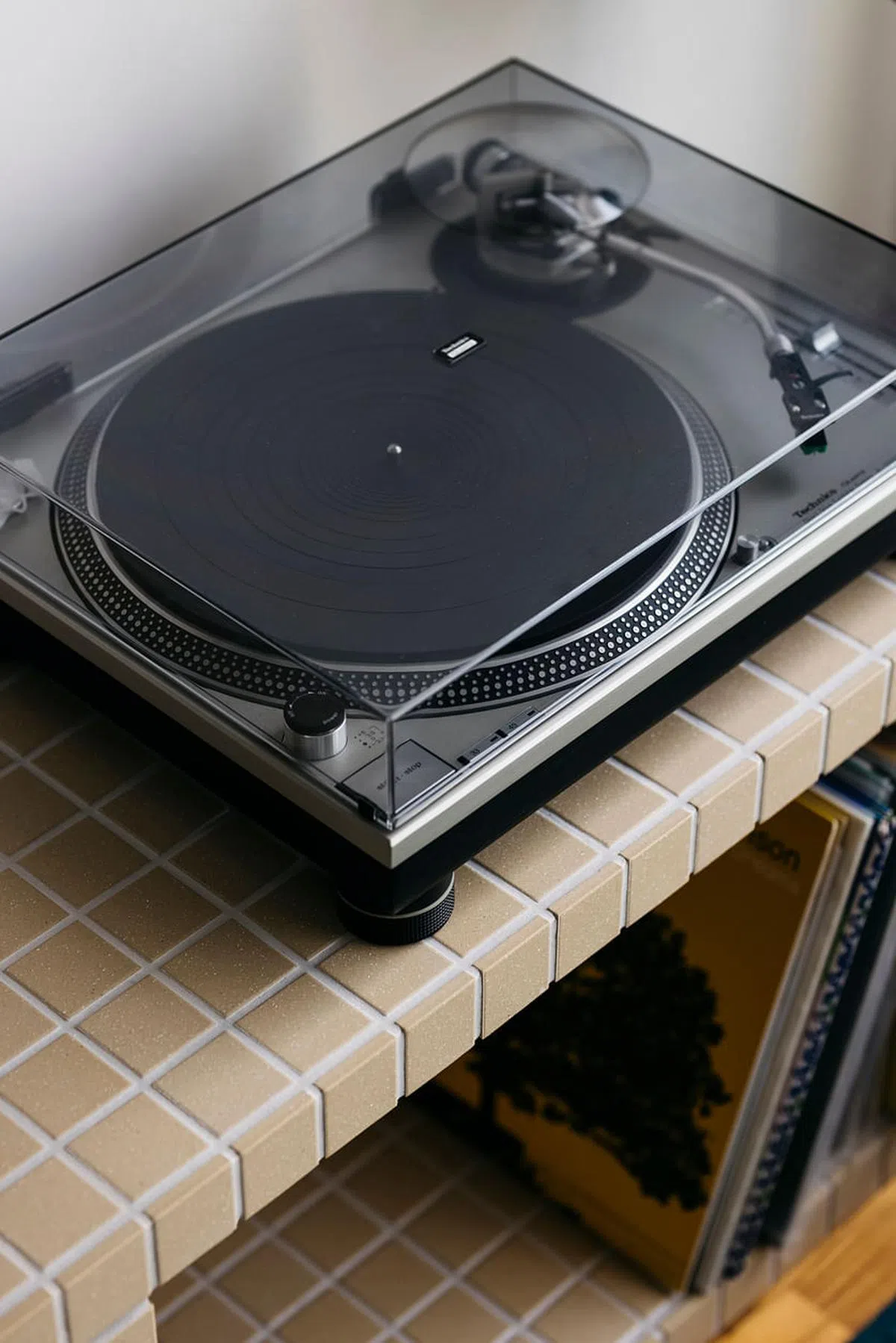设计师用米色方格瓷砖为音响发烧友的男主人打造放置音响器材和黑胶唱片的专柜。（Monocot Studio提供照片）