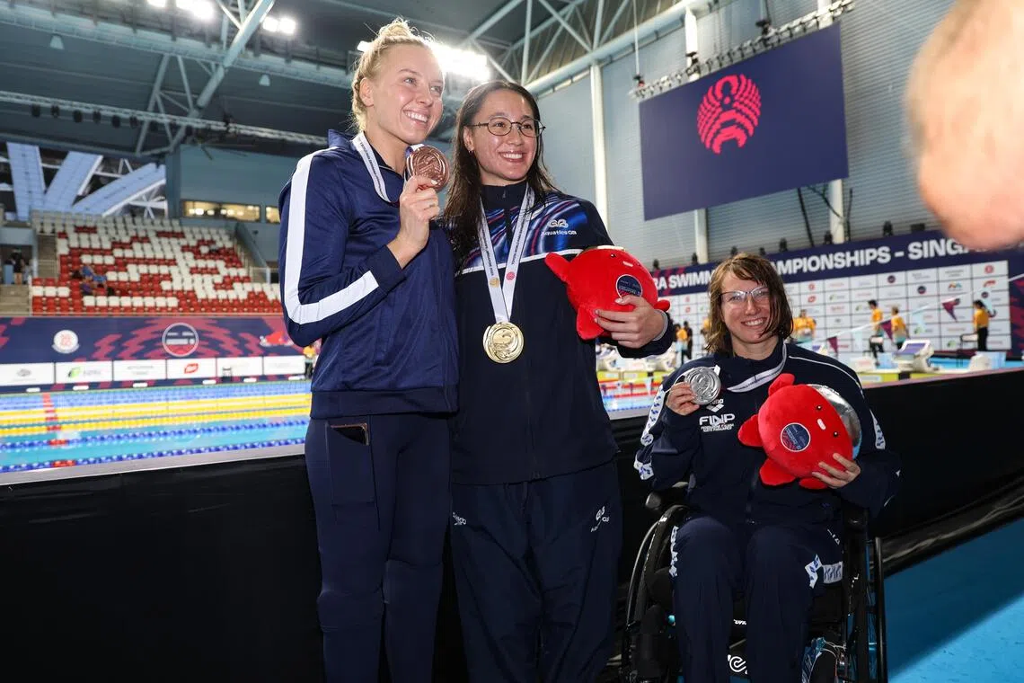 患有先天性马蹄内翻足，三年前右膝以下部分截肢的爱丽丝·戴（中）赛后说，这些年来能和杰西卡·朗（左）一起站在领奖台上是她的荣幸。右为意大利的银牌选手弗朗西斯卡·帕拉佐。（关俊威摄）