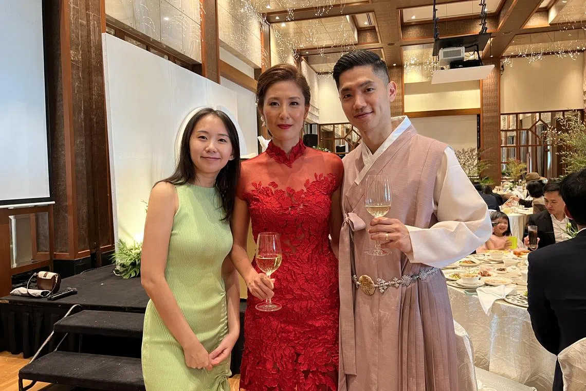 婚礼司仪黄美慧（左一）说，近年来找她用韩语主持婚礼的新人越来越多，目前约每10场婚礼就有一场有韩国亲属或宾客。图为她与一对新加坡新郎和韩国新娘合影。（受访者提供）