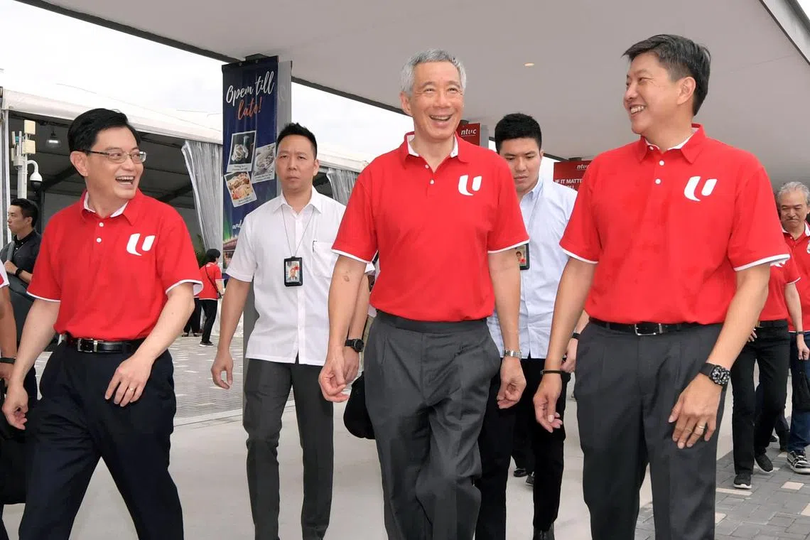 冠病疫情让副总理王瑞杰（左一）看到李显龙总理（中）如何关注可能受冠病影响的不同群体，也支持时任财政部长王瑞杰制定各种配套帮助新加坡，包括广大的工作者。图为两人出席五一劳动集会时所摄，右一是全国职工总会秘书长黄志明。（档案照）