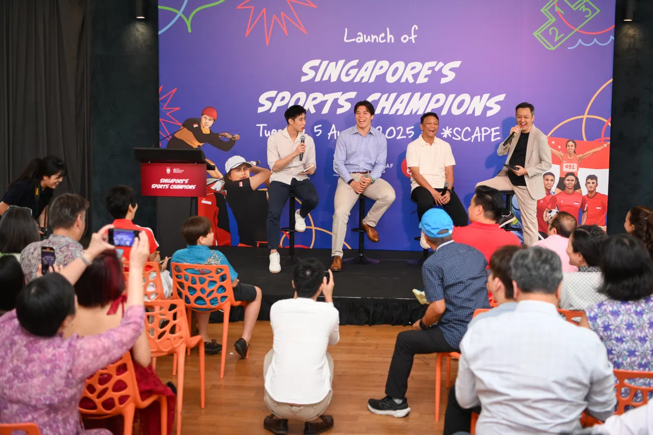 骆建佑（左起）、墨士廉和我国足球名宿范迪阿末在台上分享书中趣闻。（海峡时报）