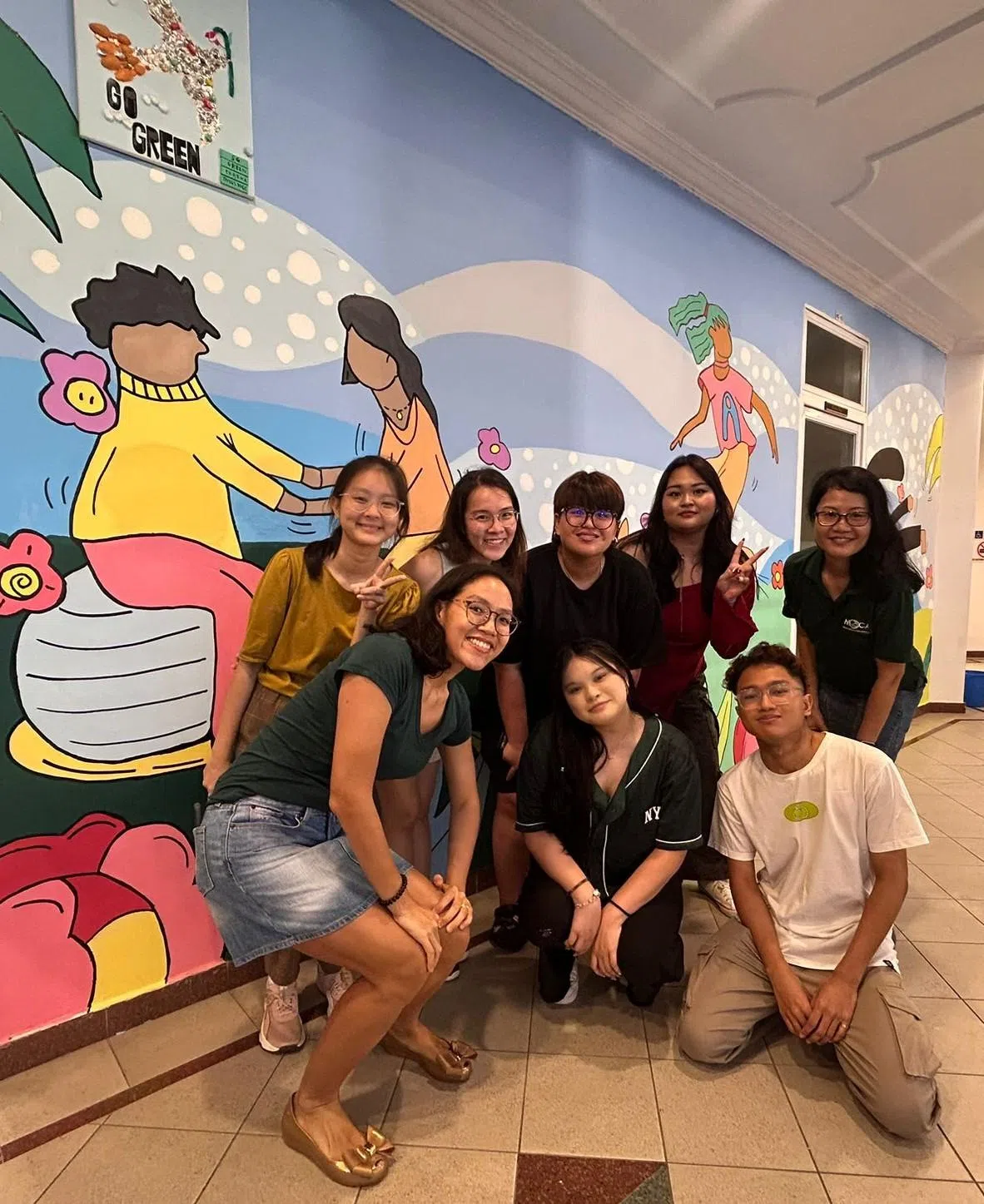 向彦婷（后排左一）与年轻义工伙伴们，在东陵民众俱乐部完成壁画绘制后一起合照。（受访者提供）