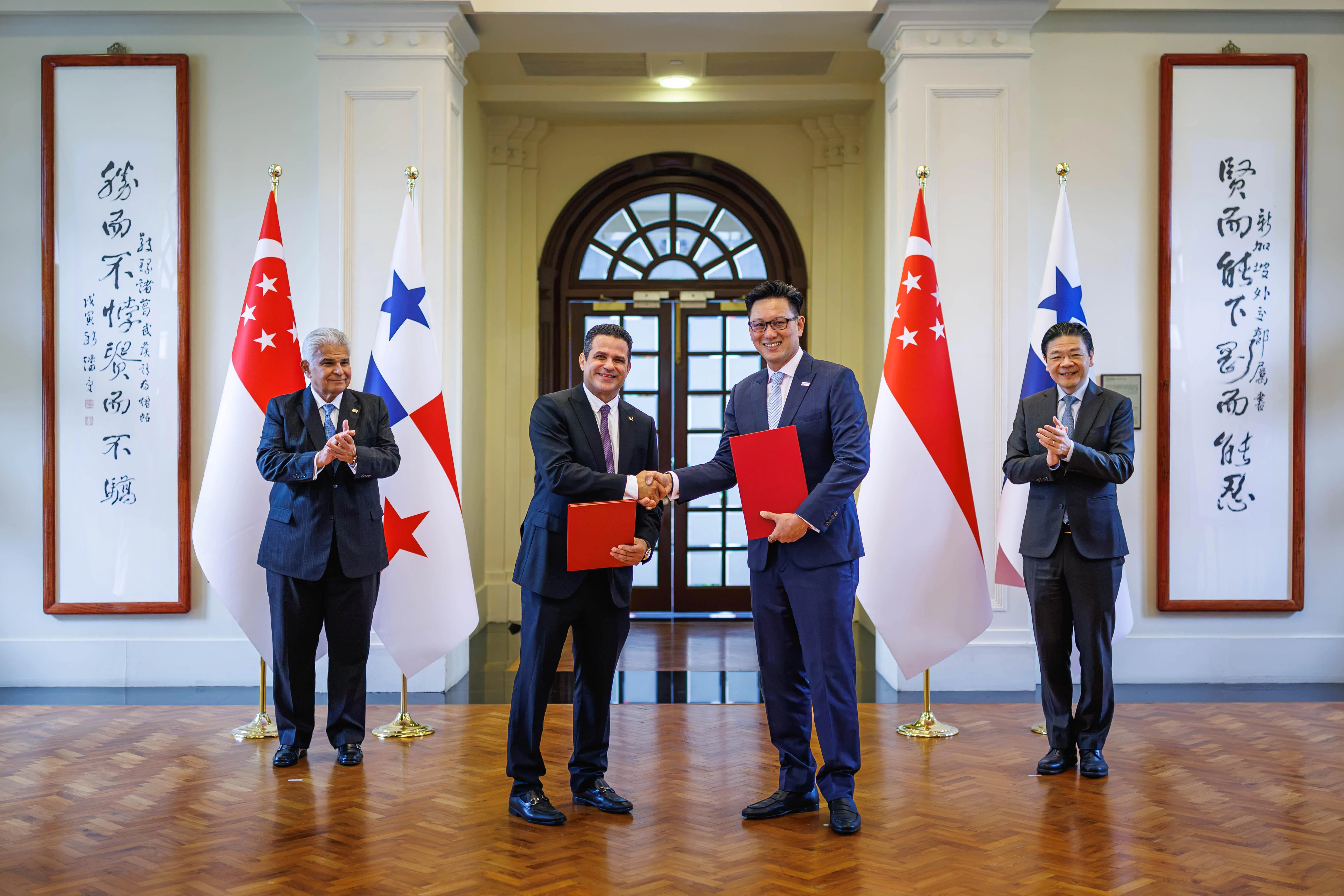 我国新翔集团总裁兼首席执行官莫智雄（右二）与巴拿马托库门国际机场总经理何塞·鲁伊斯（Jose Ruiz）交换谅解备忘录，加强互联互通及航空货运物流合作。巴拿马总统穆利诺（左一）和黄循财总理（右一）在一旁见证。（数码发展及新闻部提供）