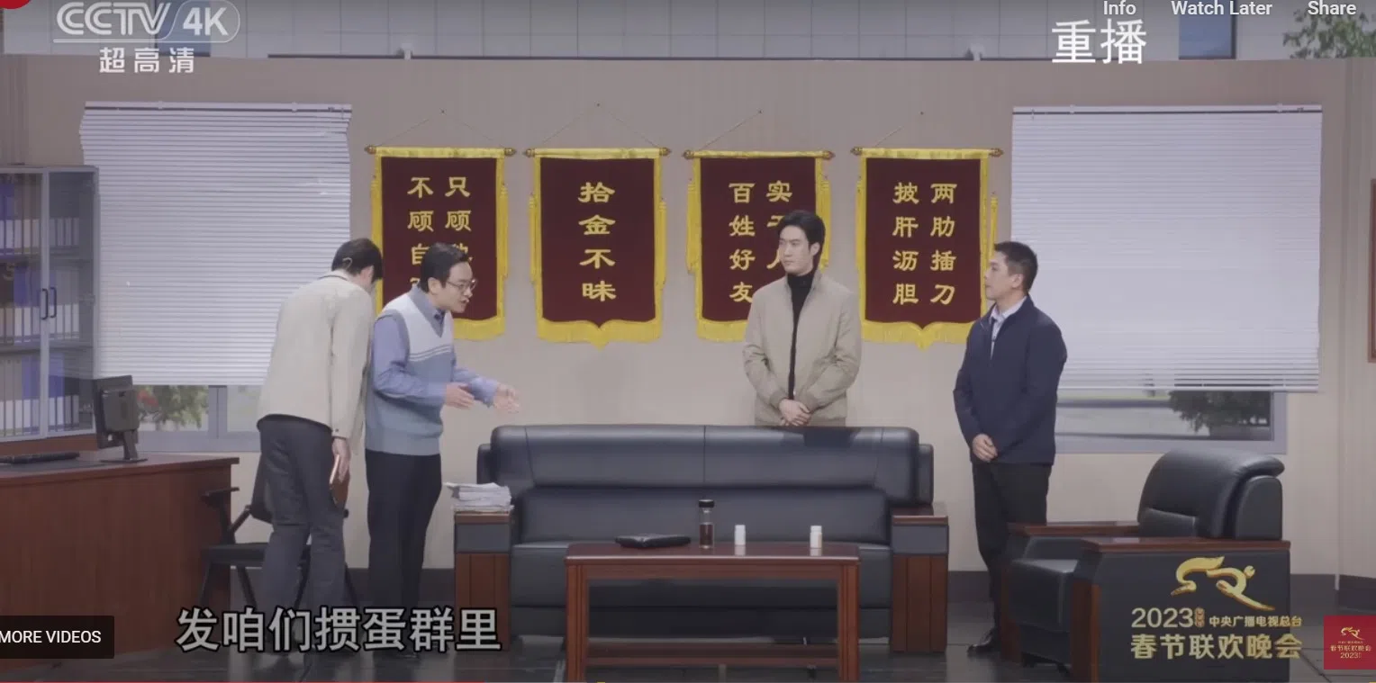 在2023年春节晚会小品《坑》中，沈腾（左二）饰演的不作为官员嘱咐下属，“赶紧把借我的那几件事儿，发咱们掼蛋群里”，引起网民热议。（央视截图）