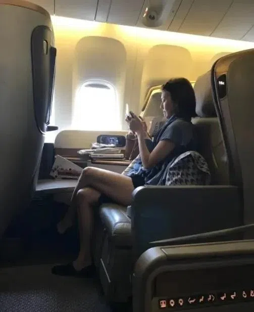 孙燕姿露出一双美腿，墨镜架在头上，眼睛专注地看着手上的东西。（互联网）