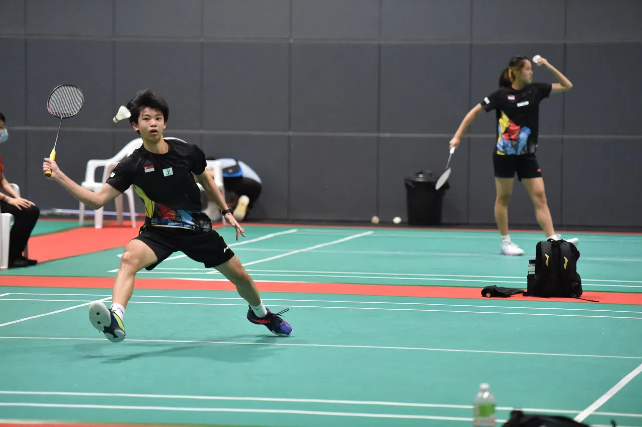 新加坡体育学校毕业生黄安锐（19岁，左）文武双全，在羽毛球场是强将，在国际文凭高中课程考试中考获40分佳绩。图为他2022年6月在本地参加Brave Sword羽毛球系列赛。（新加坡体育学校提供）