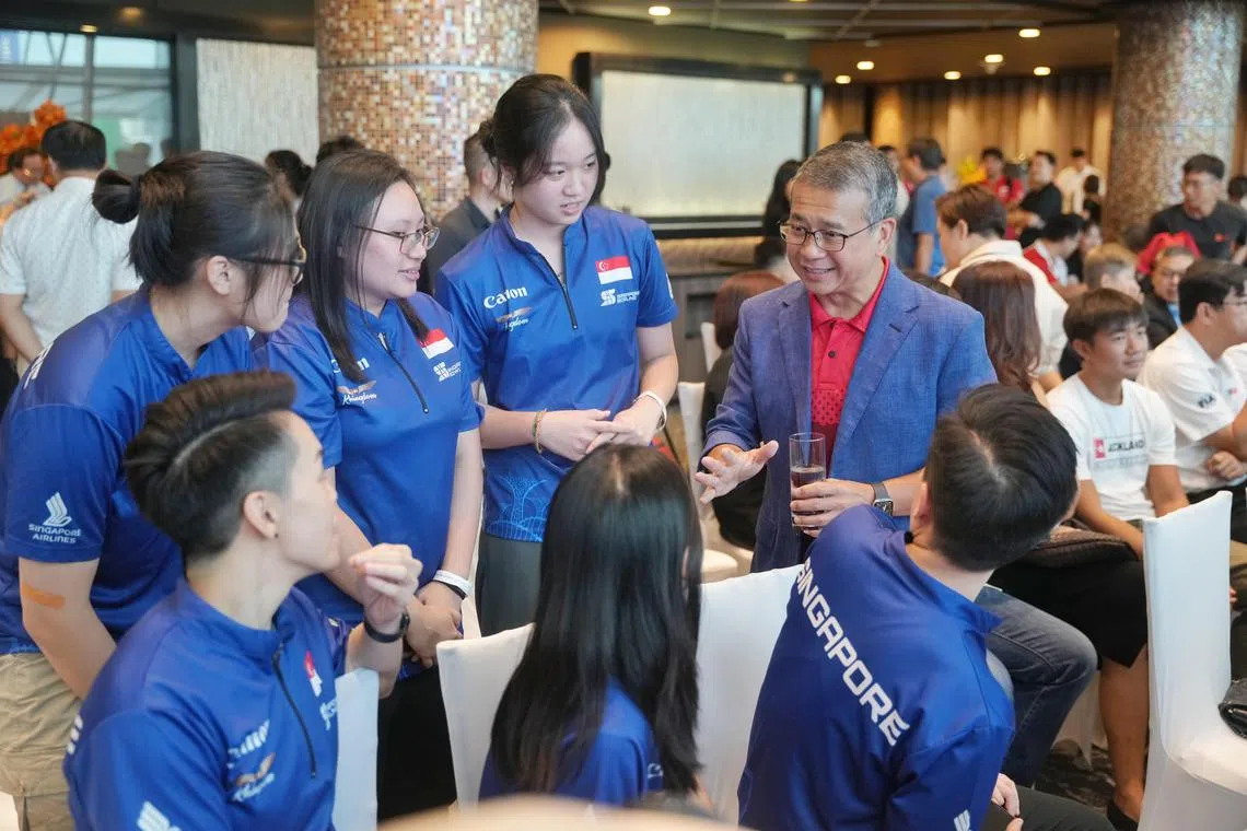 政府去年宣布调高卓越体育奖学金得主的补贴，为他们缴交公积金，对运动员帮助不小。图为文化、社区及青年部长兼律政部第二部长唐振辉（右）出席活动时和我国保龄球队交流。（档案照片）